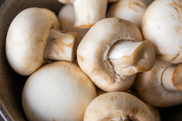 Close-up of fresh white button mushrooms on a wooden cutting board