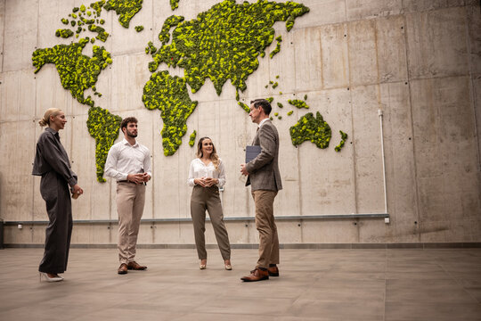 Business meeting discussing global sustainability goals in modern office