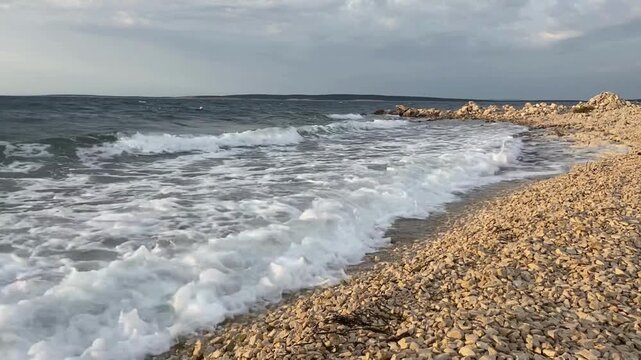 pieniące się fale na pustej plaży o wschodzie słońca
