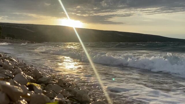 pieniące się fale na pustej plaży o wschodzie słońca