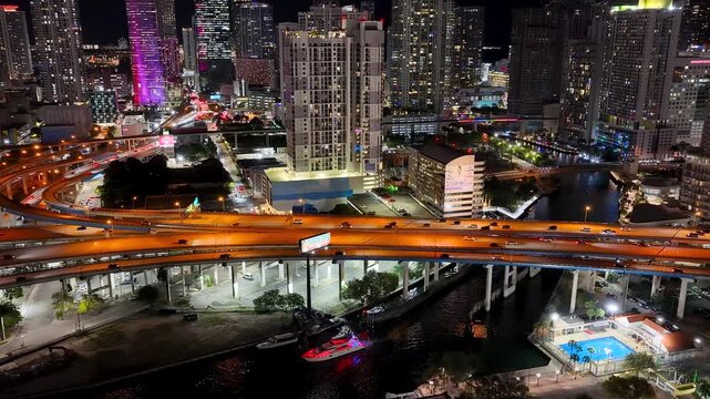 Aerial view of colorful buildings and traffic on highway in Miami downtown at night