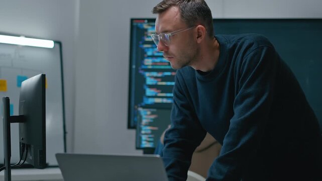 Focused professional software engineer working on laptop and agentic terminal coding in a modern office. Concept of SaaS,agentic workflow,enterprise software development and reinventing tech.