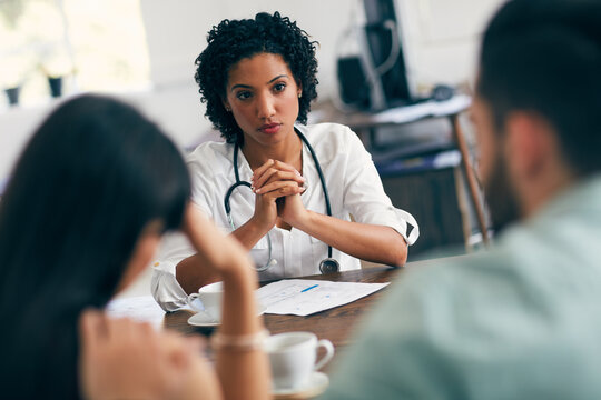 Doctor, consulting and talking with couple in office for gynecologist, ivf treatment and healthcare. Medical advice, fertility assessment and genetic testing with people in family planning clinic