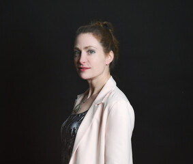 Naklejka premium Low-Key-Portrait eines Models im Mantel vor dunklem Hintergrund. Dramatisches Licht, starke Schatten und roter Lippenstift setzen elegante, ausdrucksstarke Akzente.