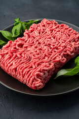 Raw ground meat on black stone table background