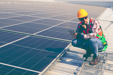 Male professional engineer installing solar photovoltaic panel system, Electrician mounting blue solar module technology on power industrial factory roof, Alternative energy, renewable energy.