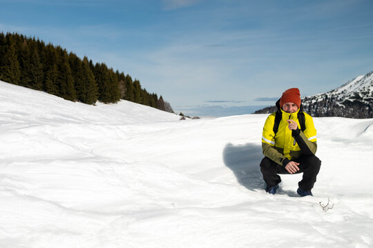 Tourist portrayed on a snow-capped mountain. The man is forty-two years old, of Caucasian origin and wears a yellow and green ski jacket