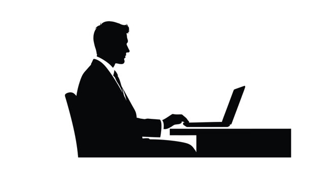 Silhouette of a businessman working intently on a laptop computer
