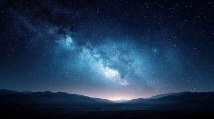 Fototapeta premium Vast Milky Way galaxy stretches across the dark night sky above silhouetted mountain ranges