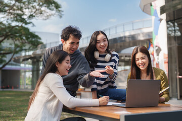 Young asian students collaborating on campus using laptop