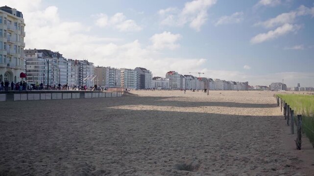 Beach of Knokke Belgium with holiday houses and clouds on sunny day