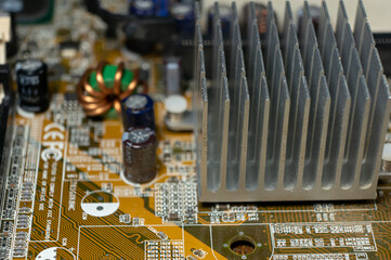 Close-up of part of an electronic circuit board with electronic components and a large chip and heat sink