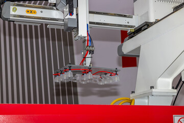 Industrial robotic arm with vacuum suction cups, on a plastic injection molding machine. Automated production line for plastic packaging