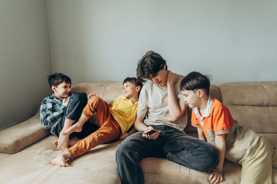Brothers relaxing and playing together on a sofa at home