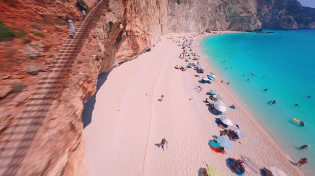 Cinematic FPV drone flight over the iconic Porto Katsiki Beach in Lefkada, Greece, revealing dramatic white cliffs, bright turquoise waters, and the stunning Mediterranean coastline.