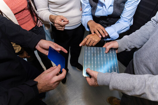 Teamwork in office discussing and showing different solar panel samples