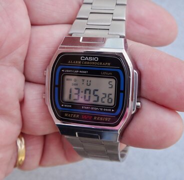 Hand wearing Casio vintage digital watch with metal strap