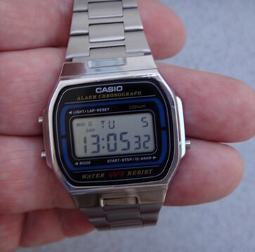 Hand holding Casio retro digital watch displaying time