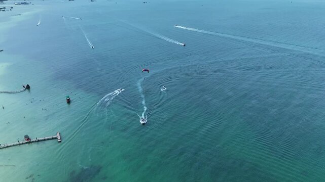Starfish Beach (Rach Vem), Phu Quoc Island, An Giang (Kien Giang), Vietnam &ndash; 4K aerial drone footage of parasailing over turquoise sea with speedboats, tropical coastline and island adventure