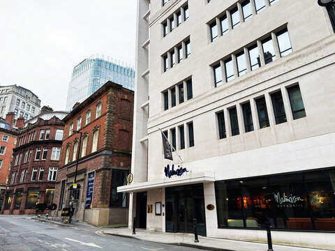 City street featuring Malmaison Bar and Grill Manchester Deansgate modern white building and historic brick townhouses
