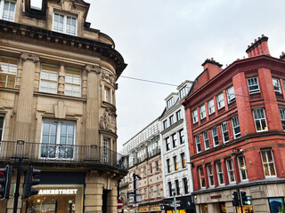 Naklejka premium Historic Manchester street scene with red brick buildings and busy storefronts