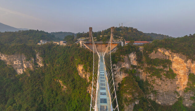 Aerial view of the stunning Glass Bridge suspended between towering cliffs, a modern marvel piercing through the lush greenery, Glassbridge, Zhangjiajie, China.