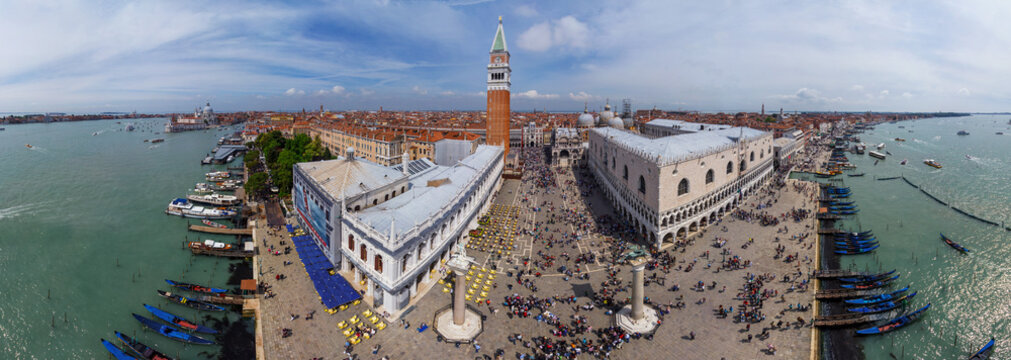 Aerial view of St. Mark's Square bustling with life, the Doge's Palace standing majestically against the turquoise waters, and the Campanile piercing the sky, Venice, Veneto, Italy.