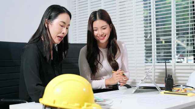 Two professional architects reviewing blueprint and color samples in modern office, interior design planning, construction project management
