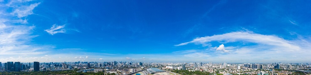 Panoramic wide-angle view of bright blue sky with delicate wispy clouds drifting across clear atmosphere in daylight, creating serene natural background ideal for design, 