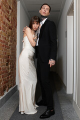 Fototapeta premium Young couple sharing a moment of love in a stylish hotel corridor