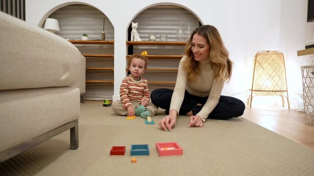Mother and toddler playing educational games on floor