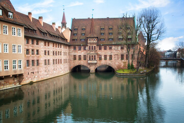 Fototapeta premium Heilig-Geist-Spital (Hospice of the Holy Spirit) in Old Town Nuremberg. View from the Museum Bridge on the River Pegnitz