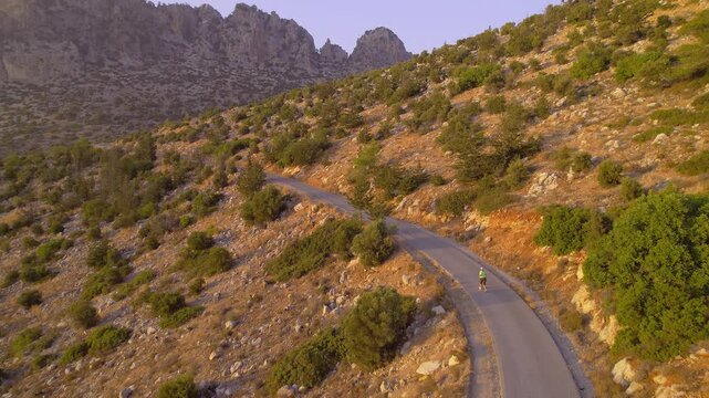 Overweight Woman Jogging on Mountain Road at Sunset in Scenic Landscape Training for Weight Loss and Fitness, drone view