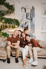 Family gathers for a cozy moment near a decorated Christmas tree