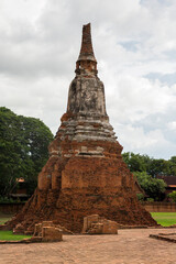 Fototapeta premium A weathered brick chedi (stupa) at the Wat Chaiwatthanaram complex in Ayutthaya, Thailand. Significant remains of plaster are still visible on the central bell-shaped section and the base of the spire