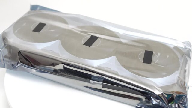 GPU graphics package protected inside a silver anti-static bag rotates on a white background for a new computer hardware assembly project