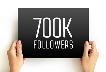 700K Followers sign on rectangular card held by hands. Minimalist social media achievement graphic...