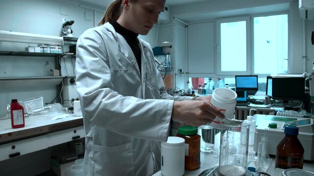 Dedicated Scientist Meticulously Combines Powders In Container To Ensure Even Distribution For Testing . Stock clip