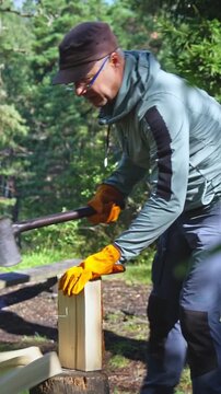 Active man preparing firewood at designated national park campfire site. Sustainable outdoor lifestyle, responsible tourism and forest management concept in sunny Finland nature.