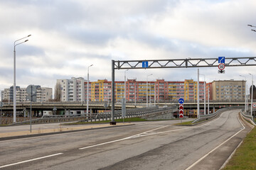 Urban road interchange with traffic signs and apartment buildings, city infrastructure in daylight