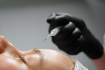 Person receiving injection for cosmetic procedure in clinic