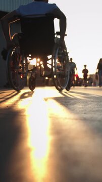 A man in a wheelchair riding in the sports park at sunst