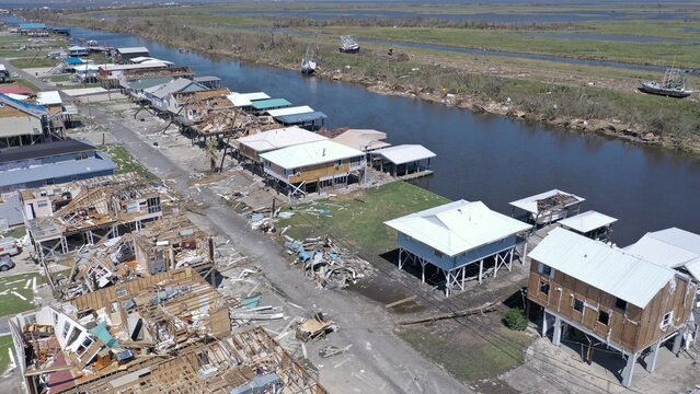 Aerial view of homes, some completely destroyed, others still standing along the water, in the aftermath of a storm, Dulac, Louisiana, United States.