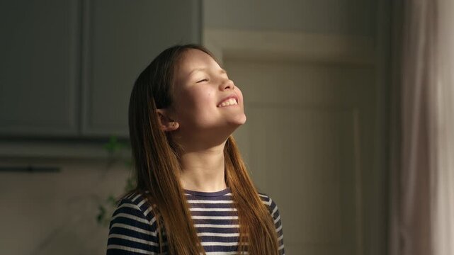 Caucasian little girl child kid blowing soapy bubbles smiling laughing at home enjoying sun shining near window happy family holiday in apartment smile daughter funny play baby game entertainment