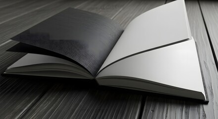 An open book with black and white pages lies on a rustic wooden surface, showcasing contrast and simplicity.