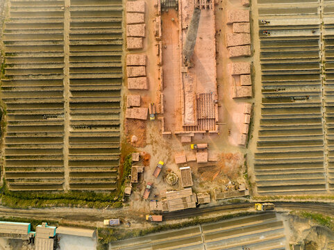 Aerial view of the brick factory with its geometric layouts, revealing a tapestry of earthy tones and textures, Aminbazar, Dhaka Division, Bangladesh.