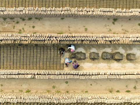 Aerial view of workers amidst rows of freshly made bricks under the open sky, Aminbazar, Dhaka Division, Bangladesh.