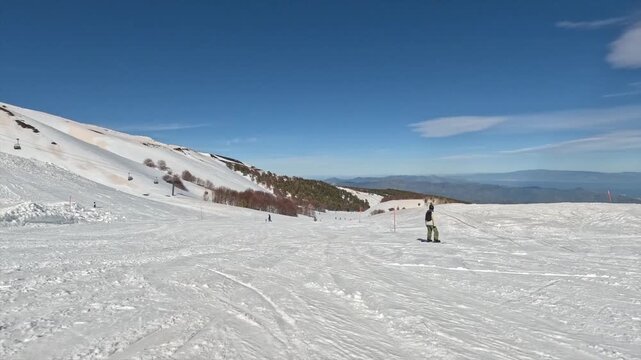 Snowboarder che scende su una pista da sci sul vulcano Etna, Linguaglossa, Sicilia 