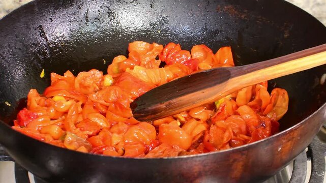 Cooking ajies peppers in caldero with wooden spoon in kitchen