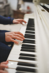 Obraz premium Hands playing piano keys in a indoor setting during daytime